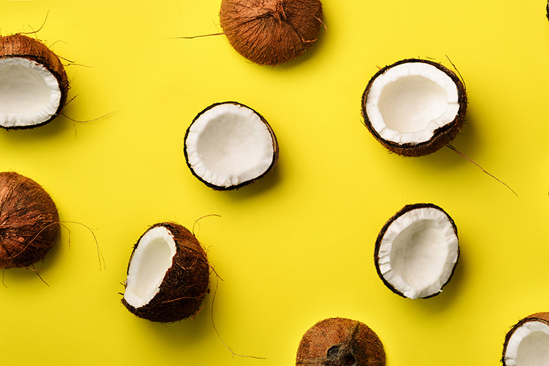 Organic MCT Oil represented by coconuts on a yellow background